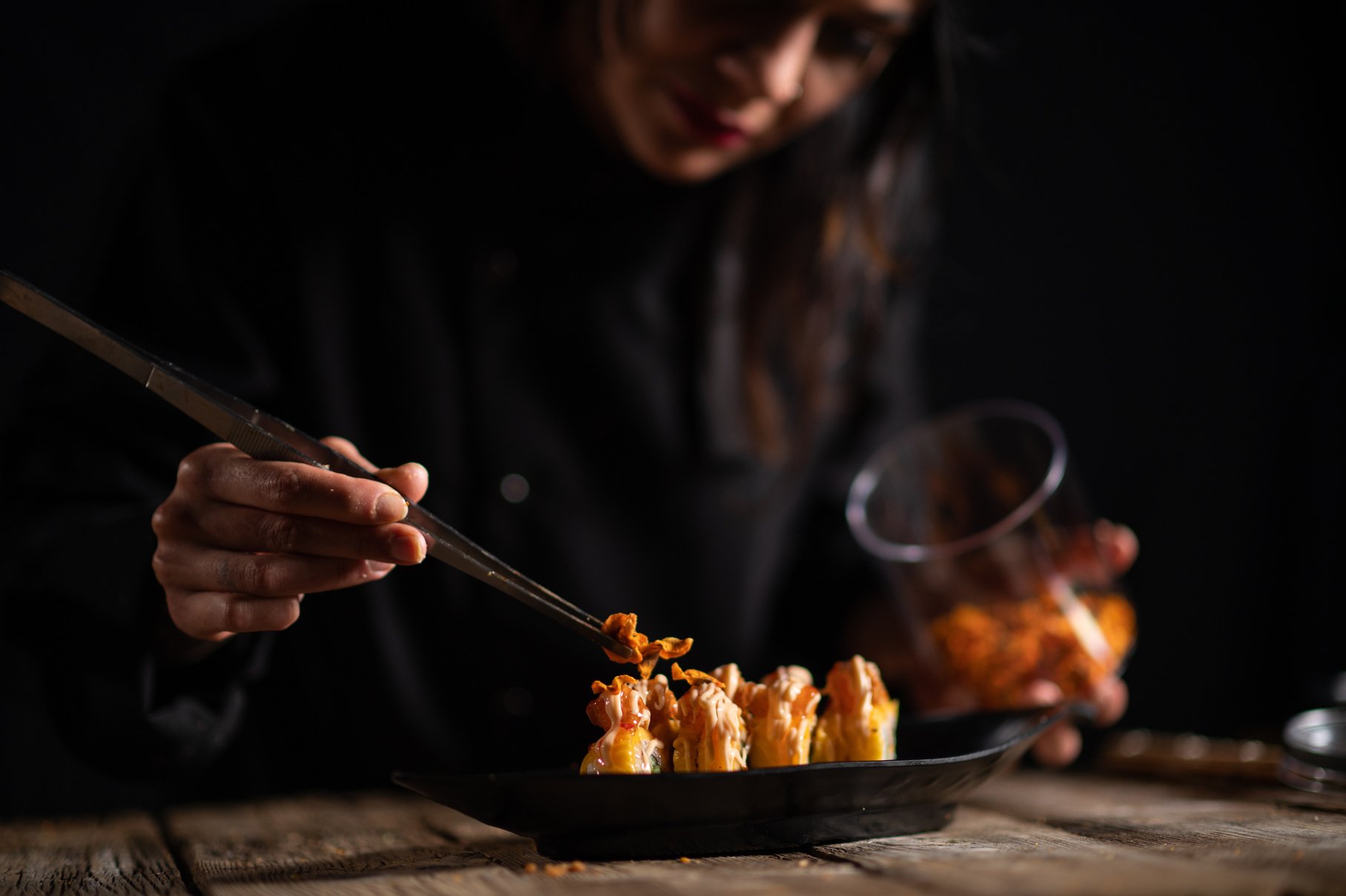 Female sushi chef making roll sushi