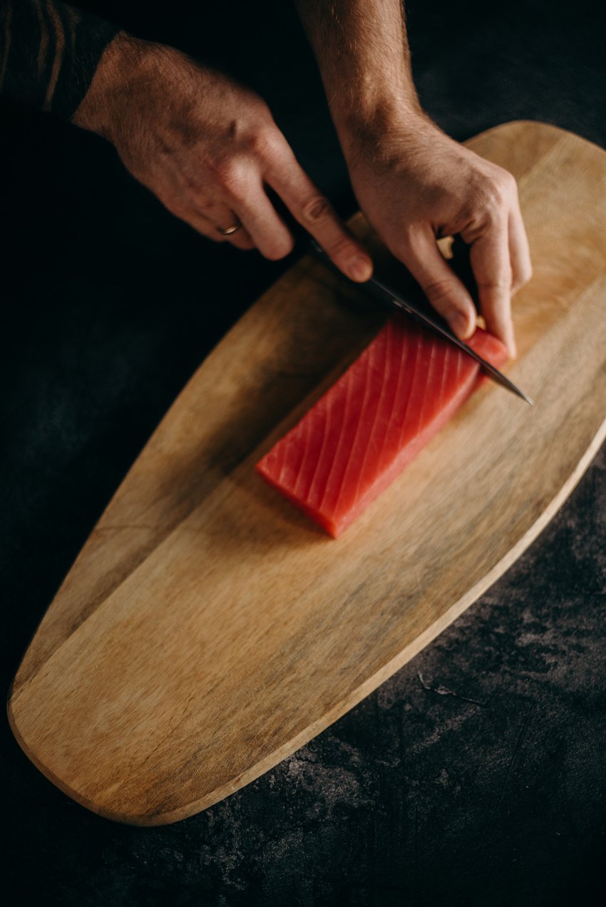 a person slicing fish meat